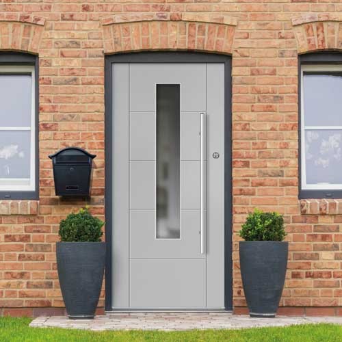 Modern grey front door with vertical glass panel and sleek handle, flanked by potted shrubs.
