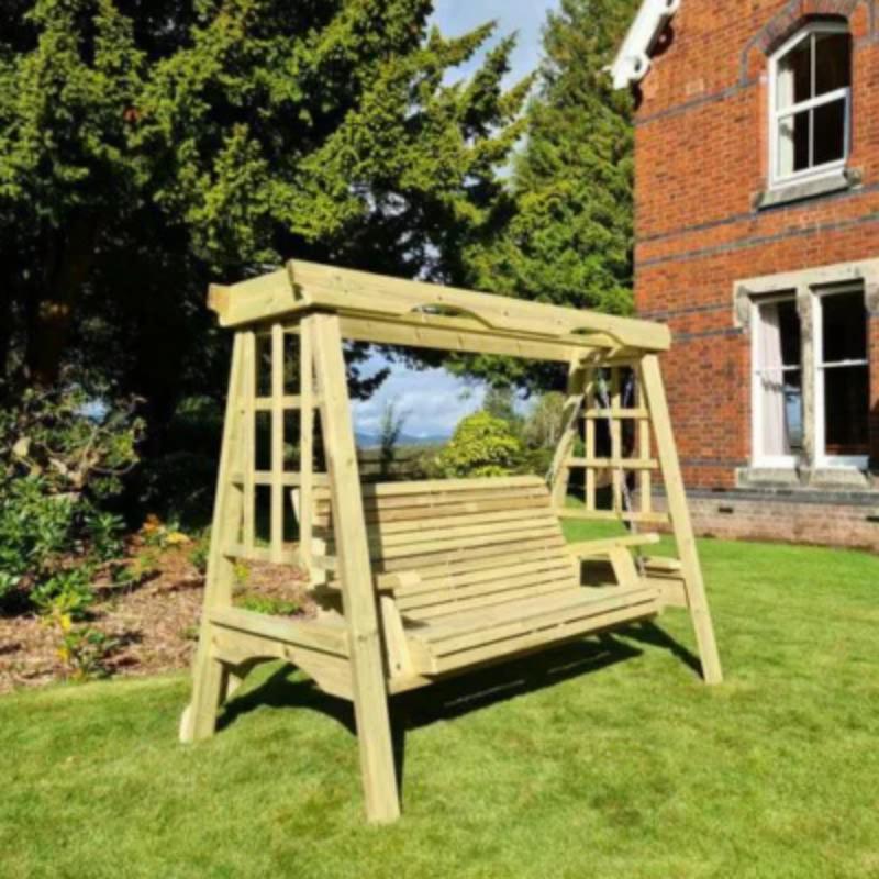 Churnet Valley wooden swing seat for three in natural finish, set in a garden with greenery